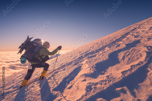 Cimbs up a snowy mountain hill