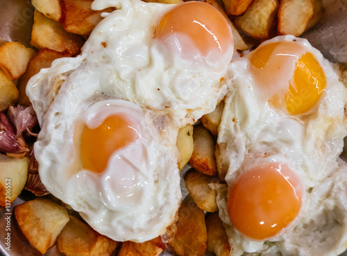 Fototapeta Naklejka Na Ścianę i Meble -  Plato de huevos fritos con patatas y ajo (huevos rotos) en una bandeja. Plato tradicional aragonés.