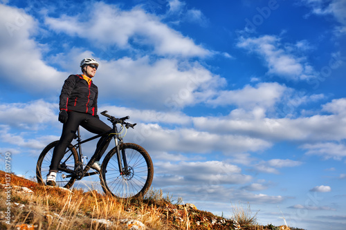 Cyclist in Black Jacket Riding the Bike Down Hill. Extreme Sport Concept. Space for Text.