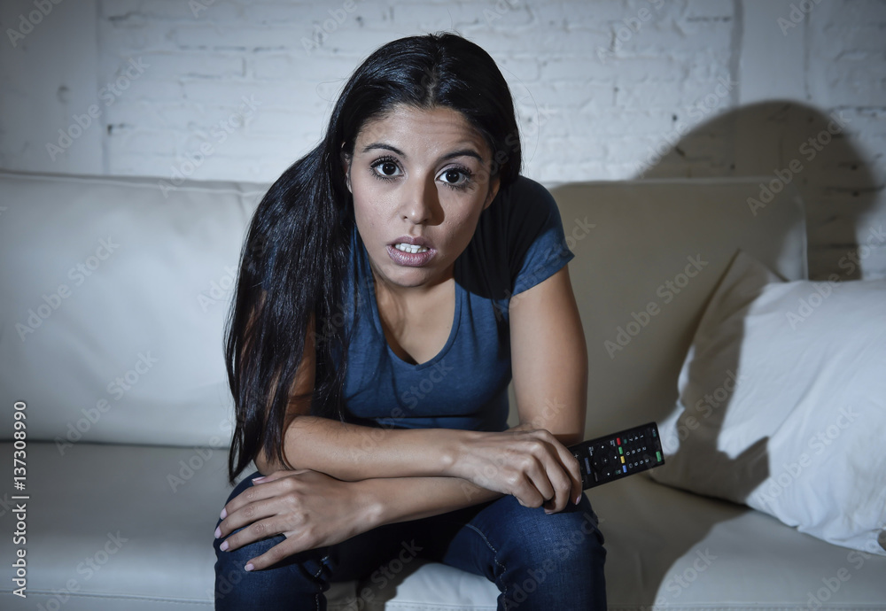 Naklejka premium woman at home sofa couch in living room watching television very concentrated and focused