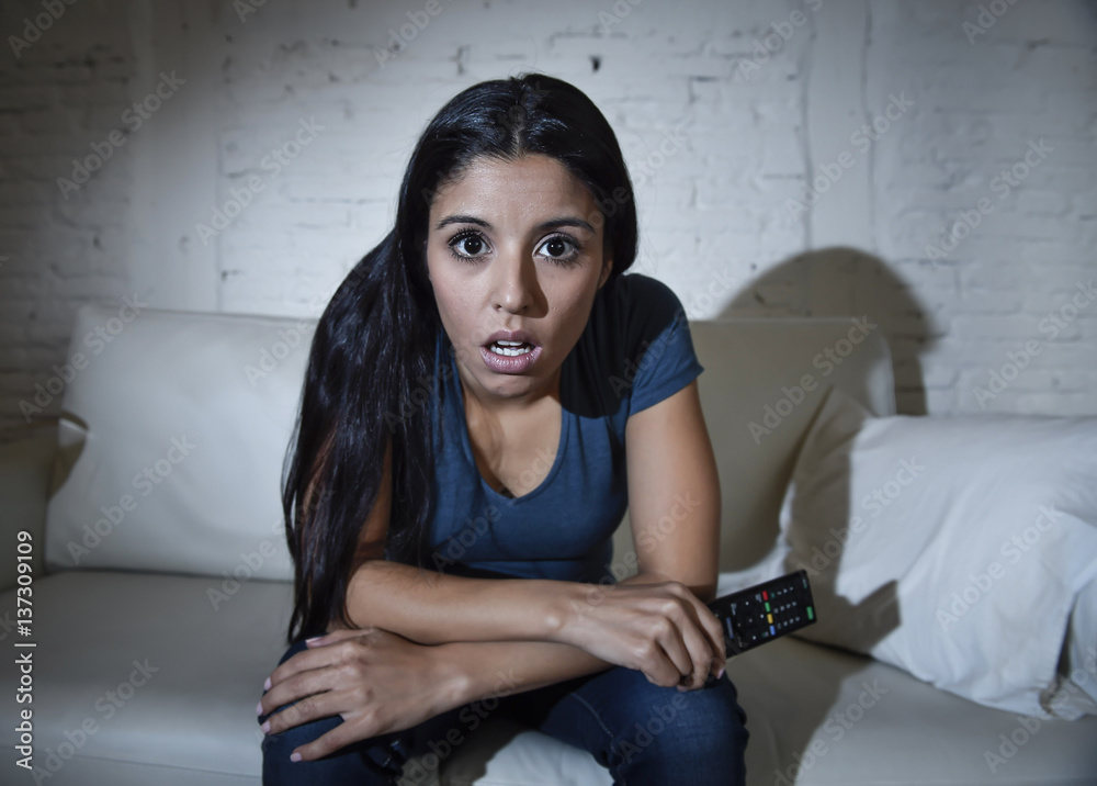 Naklejka premium woman at home sofa couch in living room watching television very concentrated and focused