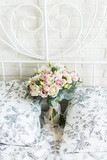 Wedding bouquet with white and pink tulips and pink small roses on a bridal bed with black and white bedclothes on a brick background