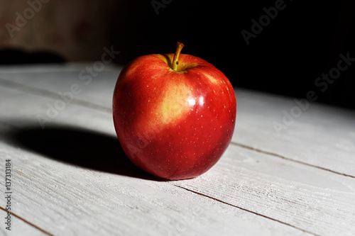 red Apple on a white table on a black background