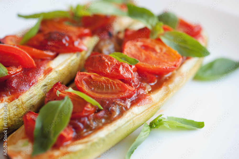 Vegetarian food. Baked zucchini with tomato and basil