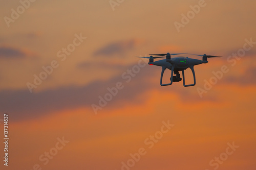 flying drone quadrocopter at sunset