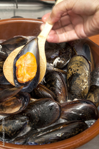 Woman hand cooking steamed mussels