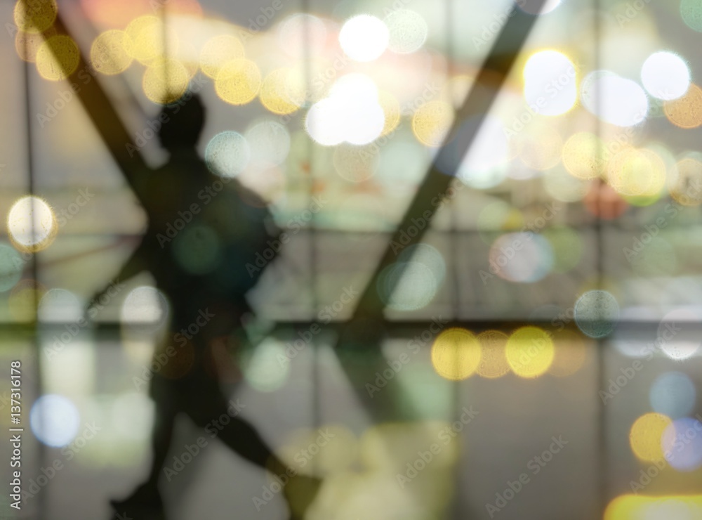 Blurred Silhouette of man with luggage walking at airport, showing something through the window. Blurred Silhouette of man with luggage walking at airport, showing something through the window.