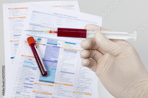 Spritze und Blutprobe und Analyseformular