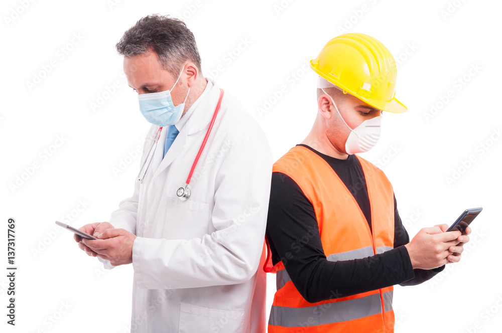 Doctor and constructor texting on their smartphones Doctor and constructor texting on their smartphones