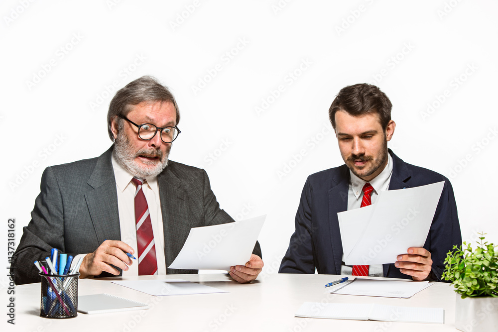 The two colleagues working together at office on white background. The two colleagues working together at office on white background.