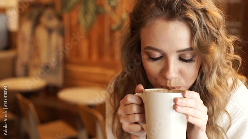 Wallpaper Mural Happy girl drinking coffee and relaxing in cafe, smiling and looking at camera. Beautiful woman with cup of coffee sitting in the coffee shop Torontodigital.ca