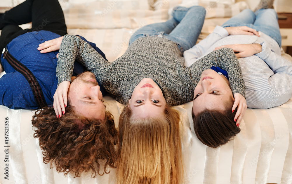 Friends laughing - Young people on bed, close friends Friends laughing - Young people on bed, close friends