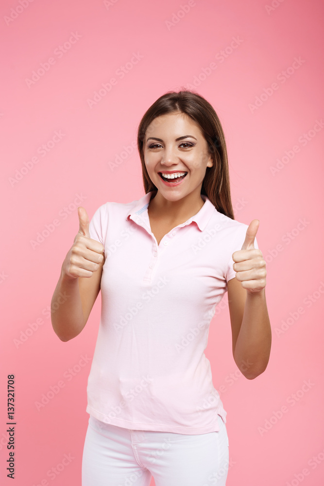 Portrait of pretty girl in pink polo showing thumb up Portrait of pretty girl in pink polo showing thumb up