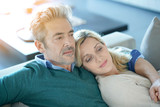Middle-aged couple relaxing together in sofa