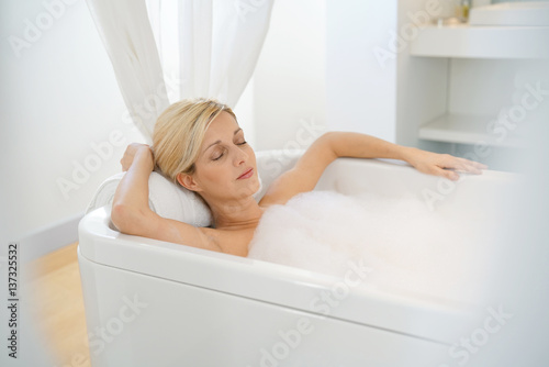 Beautiful blond woman relaxing in bathtub