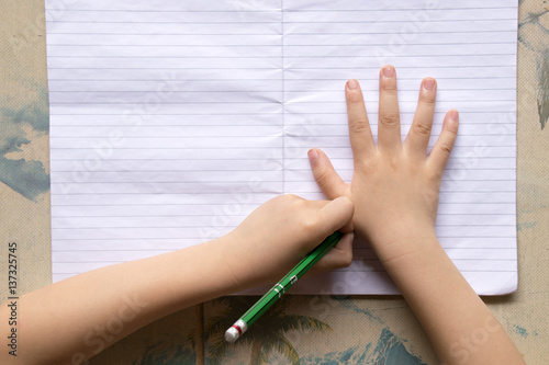 Close up Children are holding a pencil and writing.