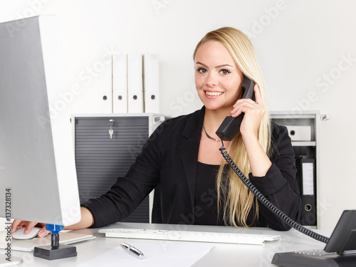 Female office assistant has a call at the office