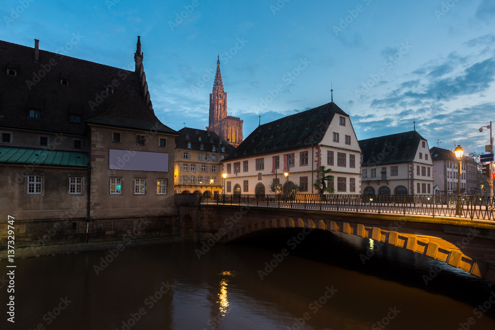View of medieval bridge Ponts Couverts and Cathedral of Our Lady (Notre Dame) of Strasbourg at night in Strasbourg, France