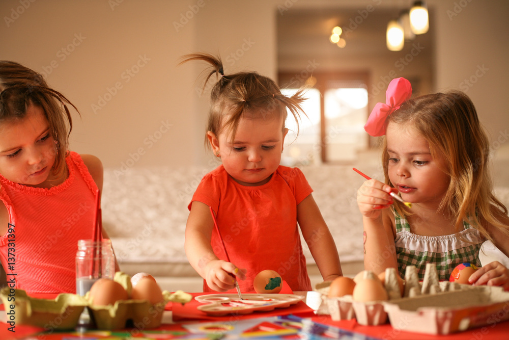 Fototapeta premium Kids Easter preparation by painting Easter eggs.