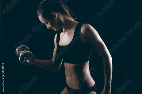 Strong fit woman exercising with dumbbells