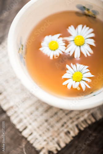 chamomile tea in a glass cup on wooden background