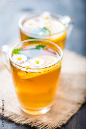 chamomile tea in a glass cup on wooden background