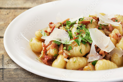 Gnocchi with parmesan and herbs on white plate