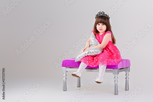 beautiful little girl in pink Princess dress with crown sitting  © producer