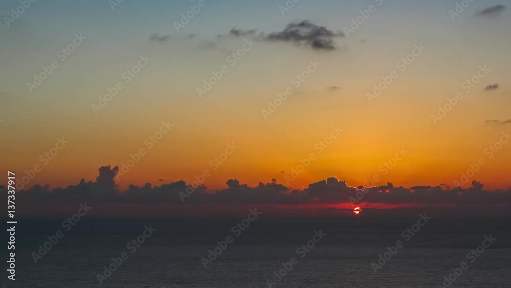 time lapse of clouds crossing the amazing sky over the sea or ocean at sunset. transition from day to night. The clouds cross slowly from left to right colored yellow orange purple blue time lapse of clouds crossing the amazing sky over the sea or ocean at sunset. transition from day to night. The clouds cross slowly from left to right colored yellow orange purple blue