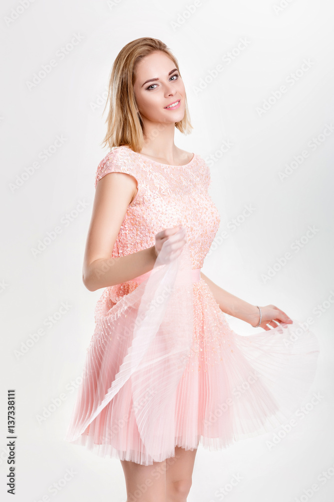 beautiful blond woman in a pink cocktail dress dancing and havin