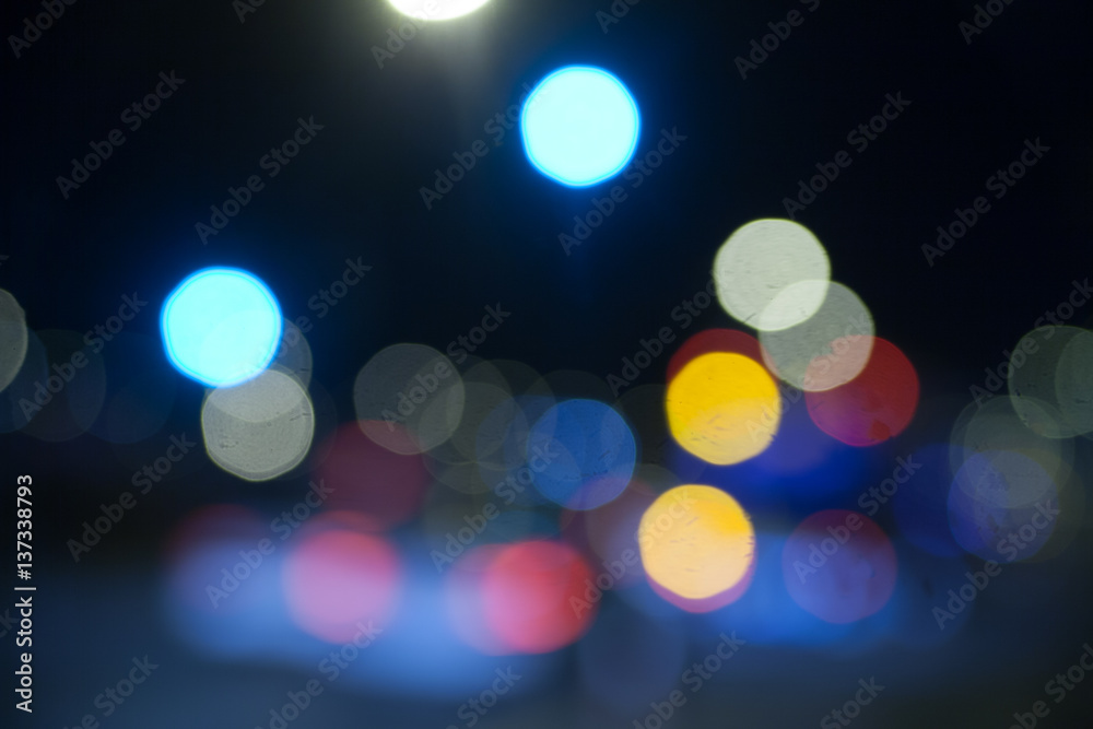 De focused/Blurred image of night city. Vehicles on the road.