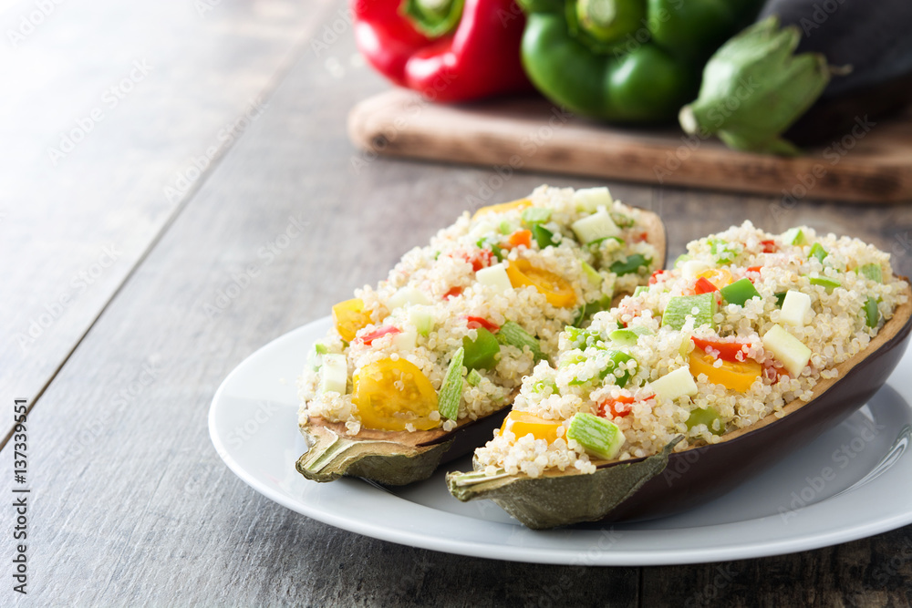 Stuffed eggplant with quinoa and vegetables on wooden background
Stuffed eggplant with quinoa and vegetables on wooden background