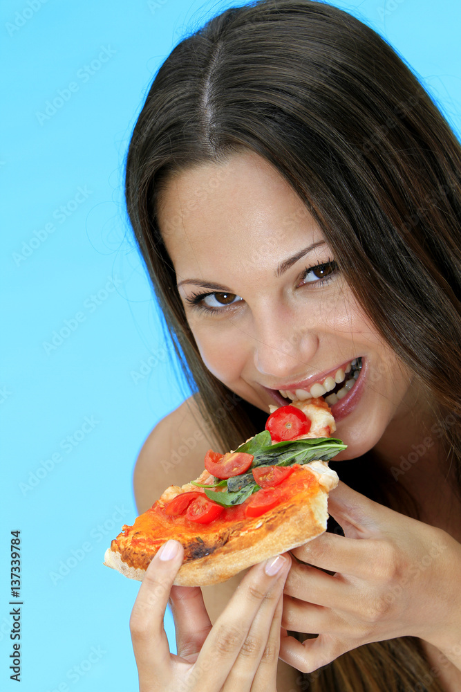 Young woman eating a pizza at the pool on holiday