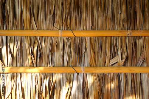 House's wall made from dried leaves of the nipa palm and bamboo. old wall textured background. photo