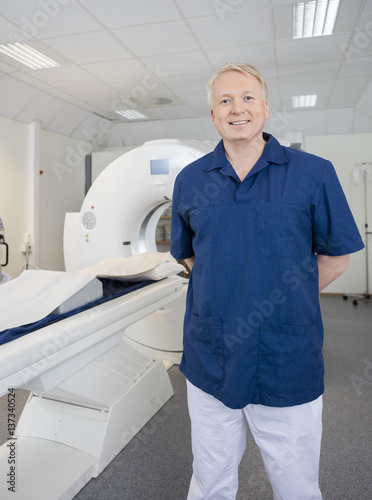 Radiologist Standing By MRI Machine In Clinic