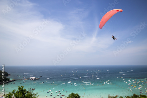 Paraglider flying over mountains in Larn Island Thailand
