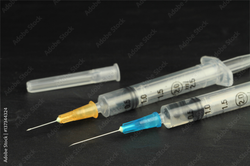 Medical injection syringes with solution on black background. Macro image. Medical injection syringes with solution on black background. Macro image.