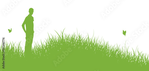 Junger Mann steht auf Wiese