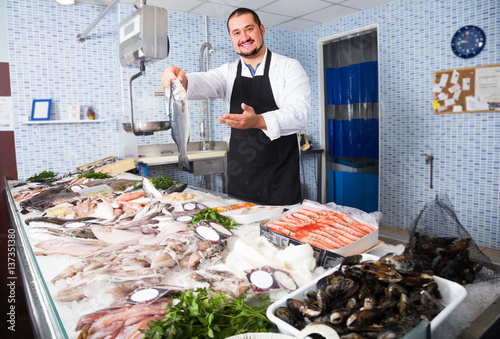 Photography Man  behind counter holding fish