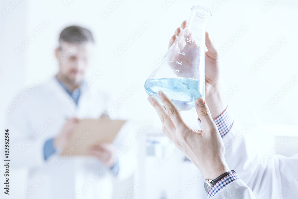 Scientist holding vessel with liquid