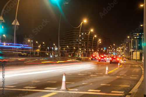 Night traffic, cars light trails on the road on evening night in busy city, urban view.
