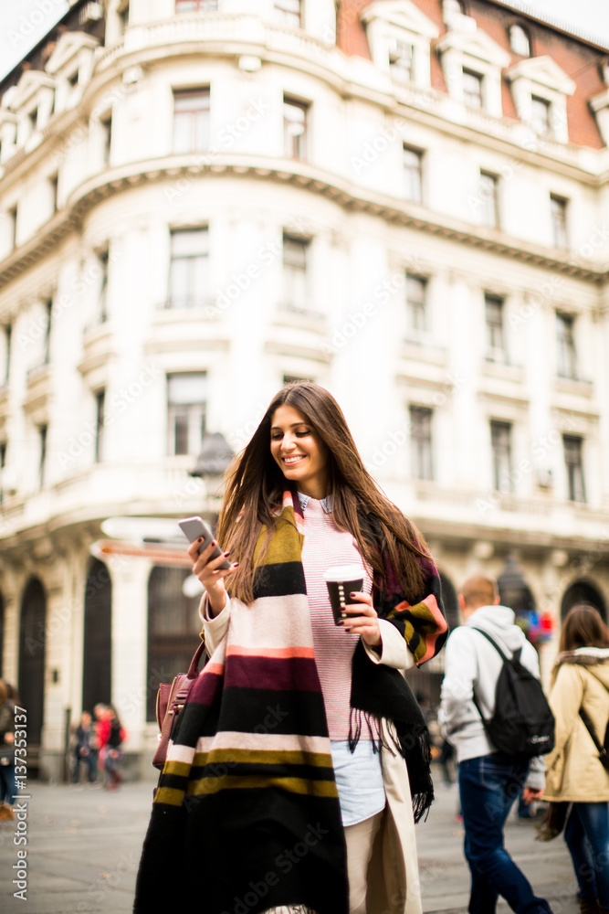 Young woman with cell phone walking on the street Young woman with cell phone walking on the street