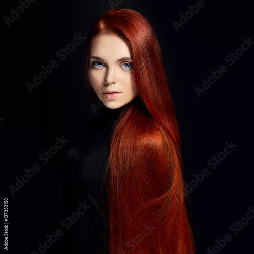 Sexy beautiful redhead girl with long hair in dress cotton retro. Woman portrait on black background. Deep eyes. Natural beauty, clean skin, facial care and hair. Strong and thick hair. Flower