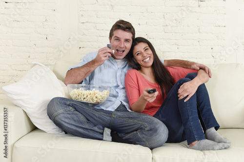 happy attractive couple having fun at home enjoying watching television movie