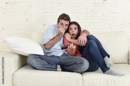 attractive couple having fun at home enjoying watching television horror movie show