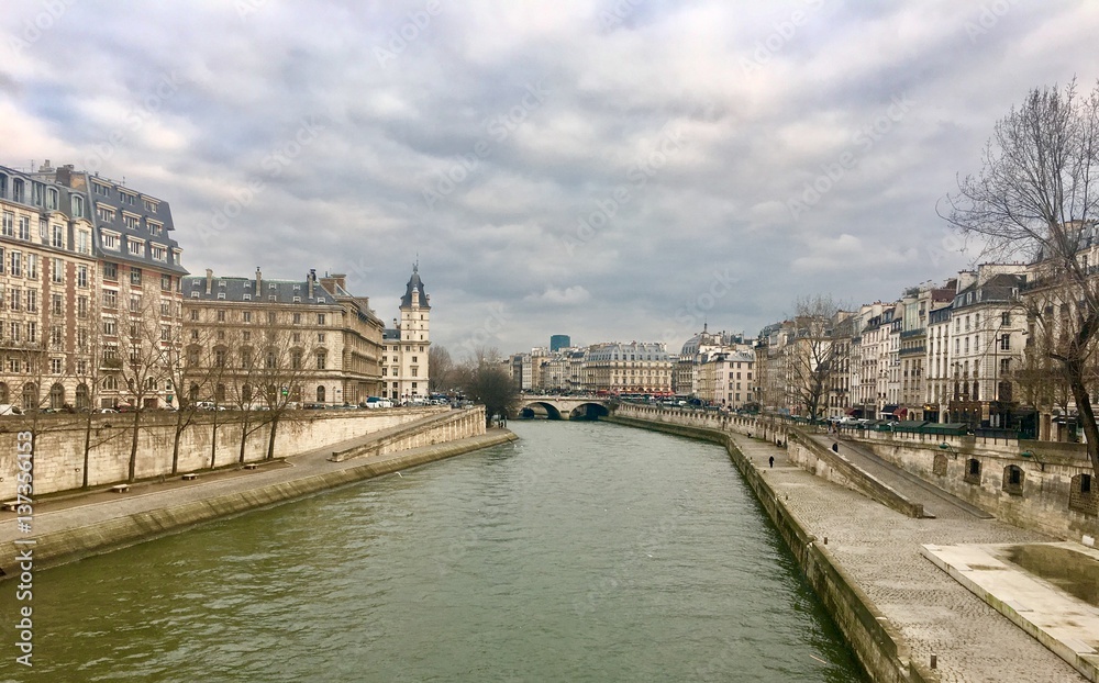 View of the Seine river with view of left and right banks in Paris from bridge on a cold winter day