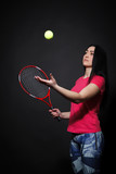 Woman with a tennis racket in his hand throwing a tennis ball