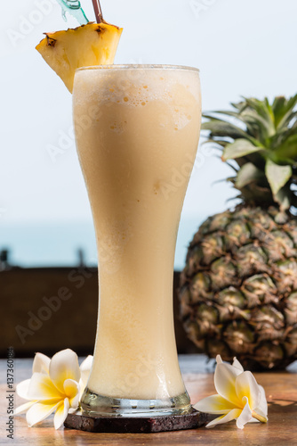 Pineapple milkshake in glass on table photo