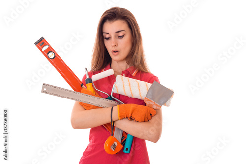tired young slim builder girl makes renovations with tools in her hands isolated on white background