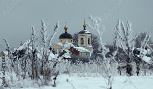 winter landscape with snow-covered church and wildflowers